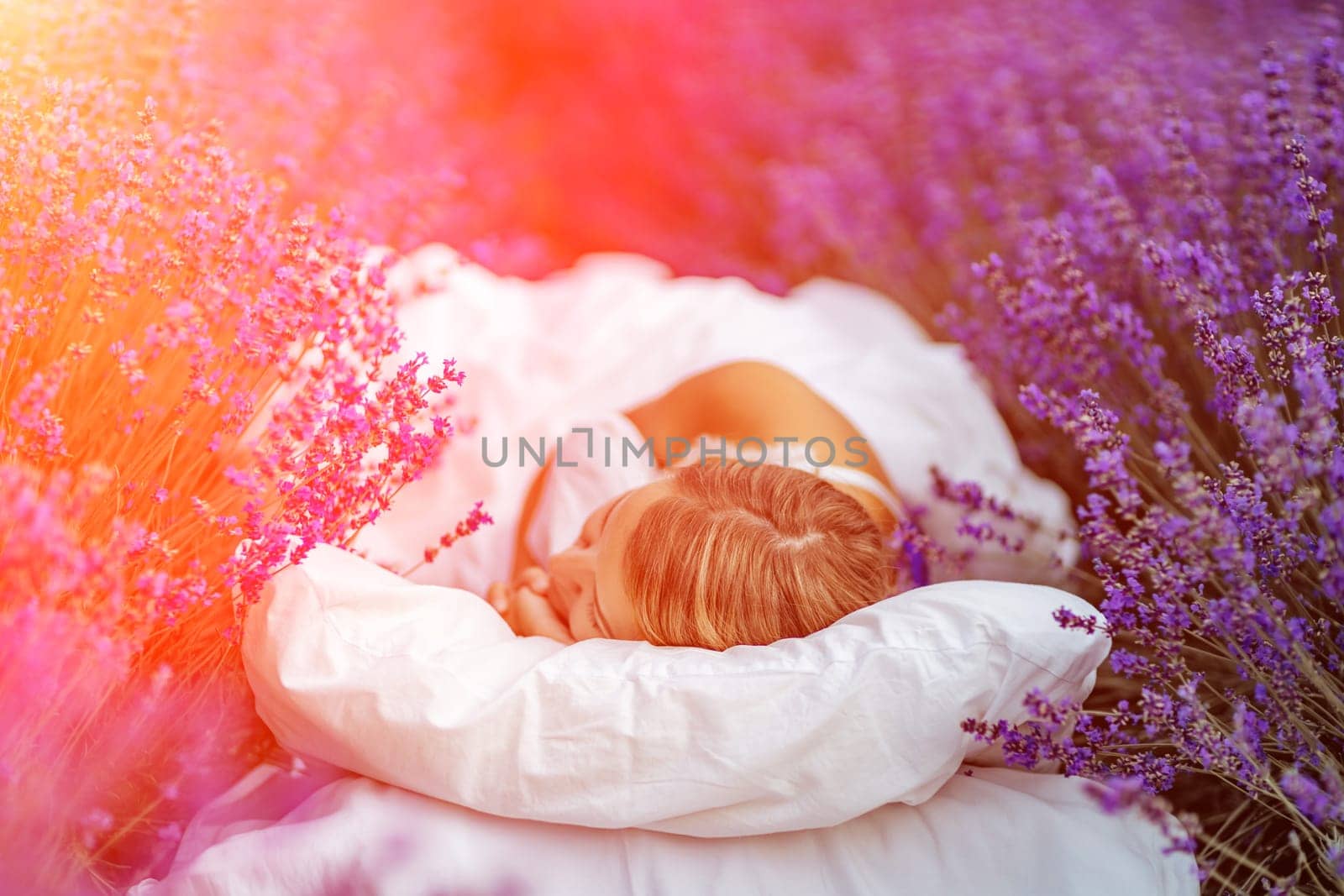 Woman lavender field. A middle-aged woman lies in a lavender field and enjoys aromatherapy. Aromatherapy concept, lavender oil, photo session in lavender.