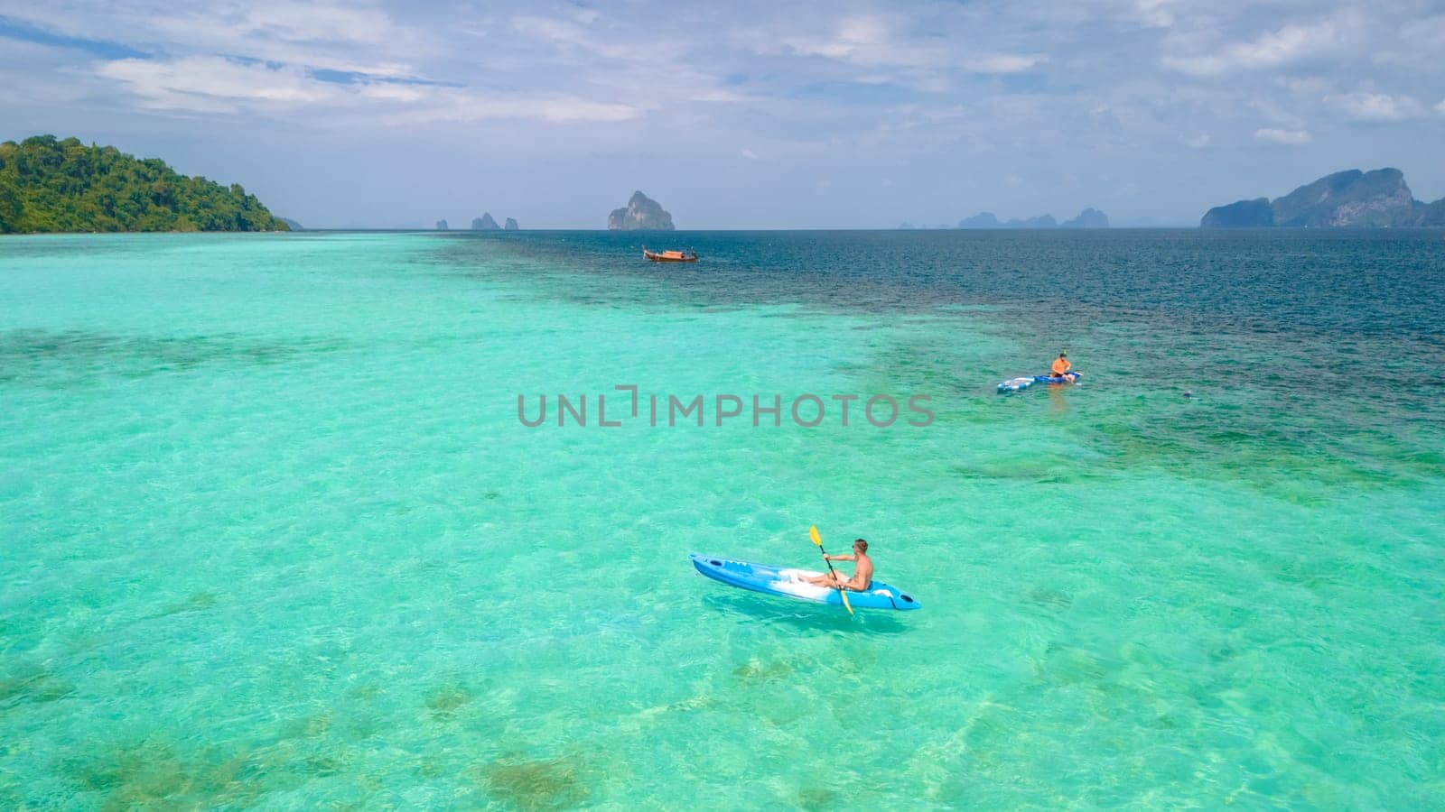 Young men in a kayak at the bleu turqouse colored ocean of Koh Kradan a tropical island with a coral reef in the ocean, Koh Kradan Trang Thailand