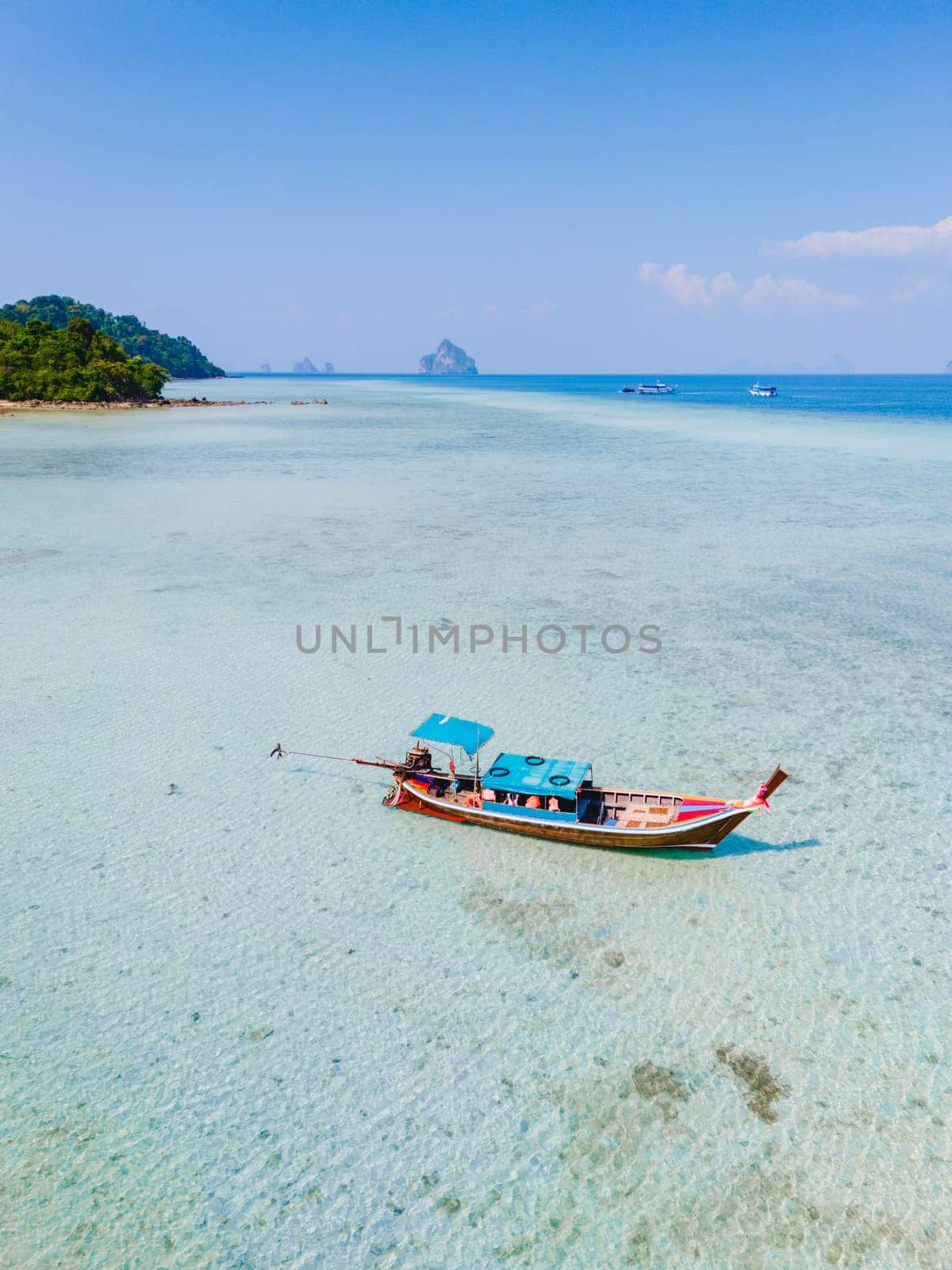 longtail boat in the turqouse colored ocean with clear water at Koh Kradan a tropical island in Trang Thailand