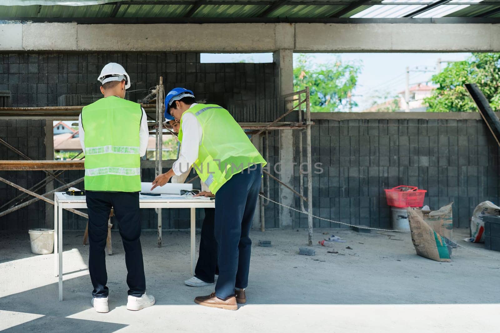 team engineer, foreman, architect meeting for colleagues discussing and checks construction blueprints at onsite.