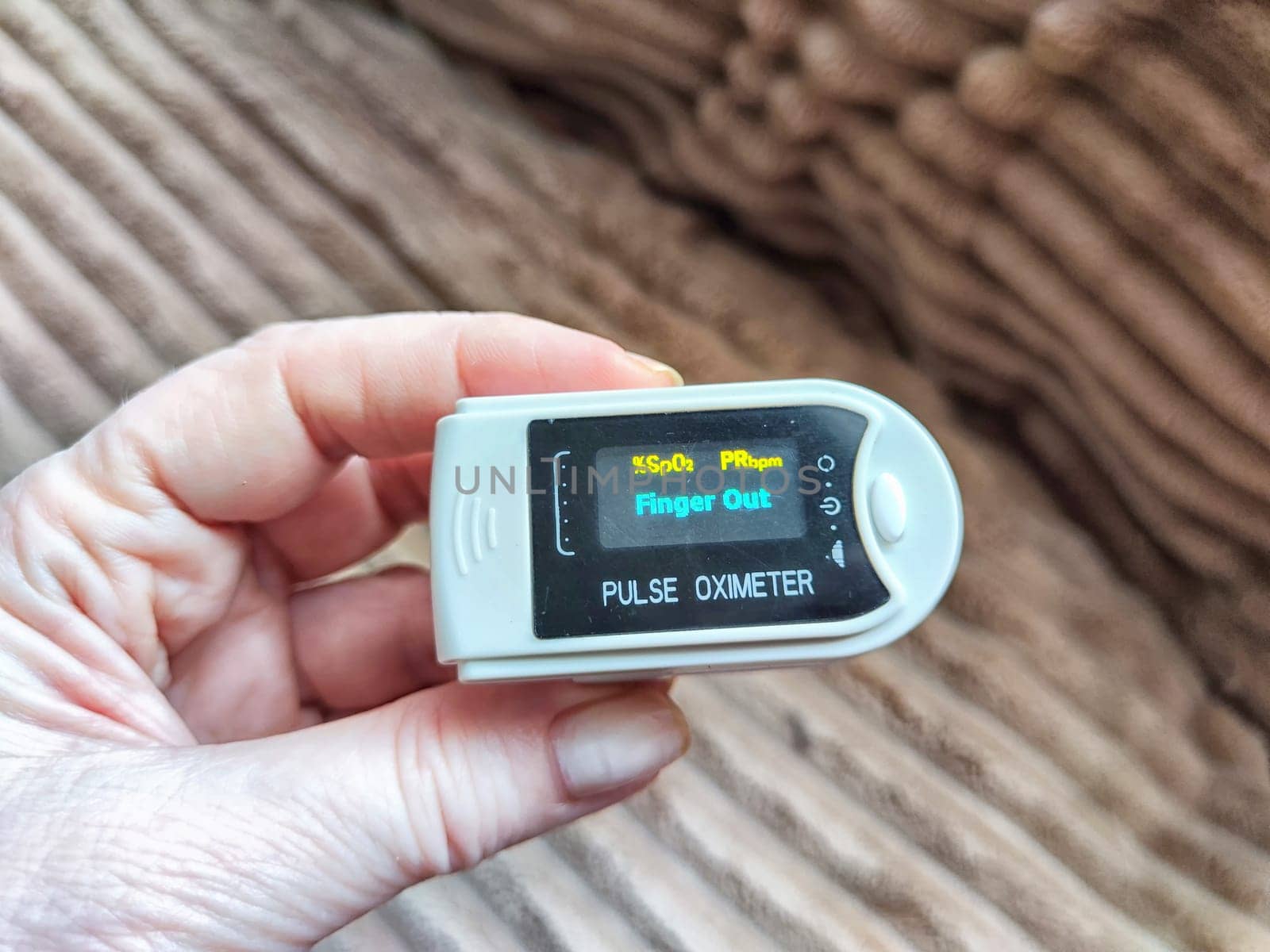 Close up of hand with a pulse oximeter on the finger.