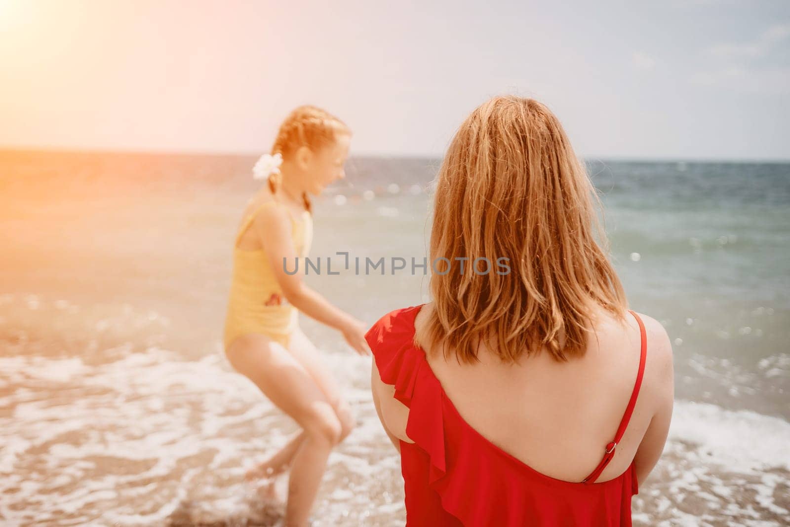 Happy loving family mother and daughter having fun together on the beach. Mum playing with her kid in holiday vacation next to the ocean - Family lifestyle and love concept by panophotograph