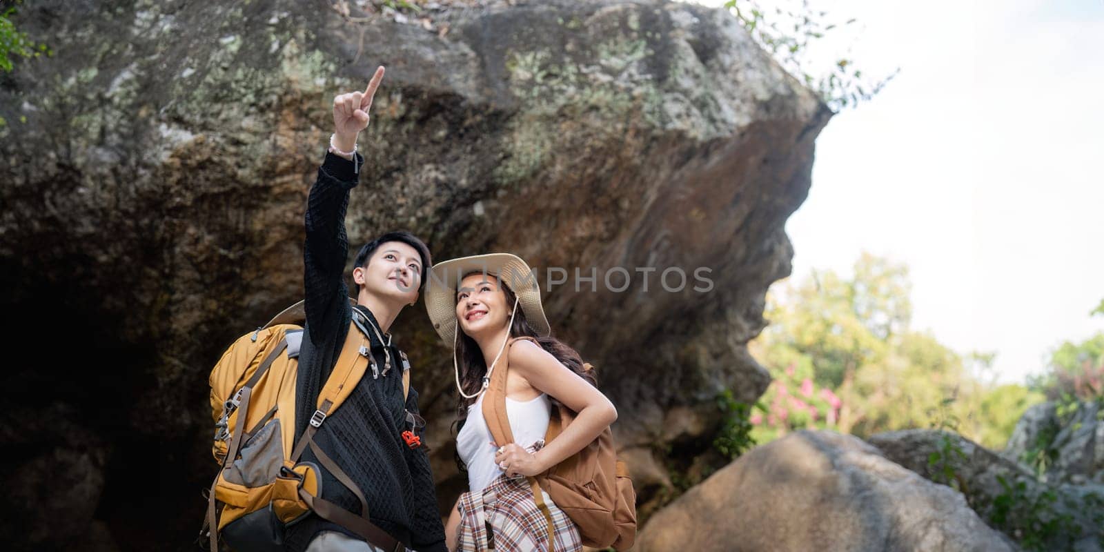 Lovely couple lesbian woman with backpack hiking in nature. Loving LGBT romantic moment in mountains.