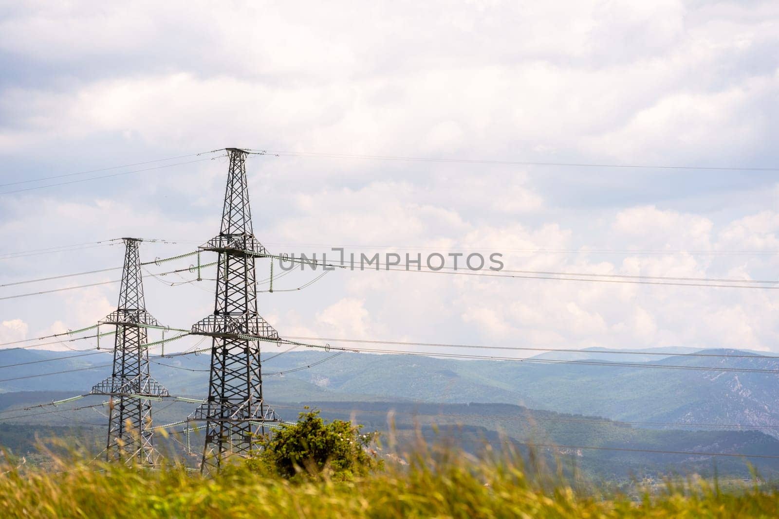 High voltage towers Electric pole. Power line support with wires for electricity transmission. High voltage grid tower with wire cable at distribution station. Energy industry, energy saving.
