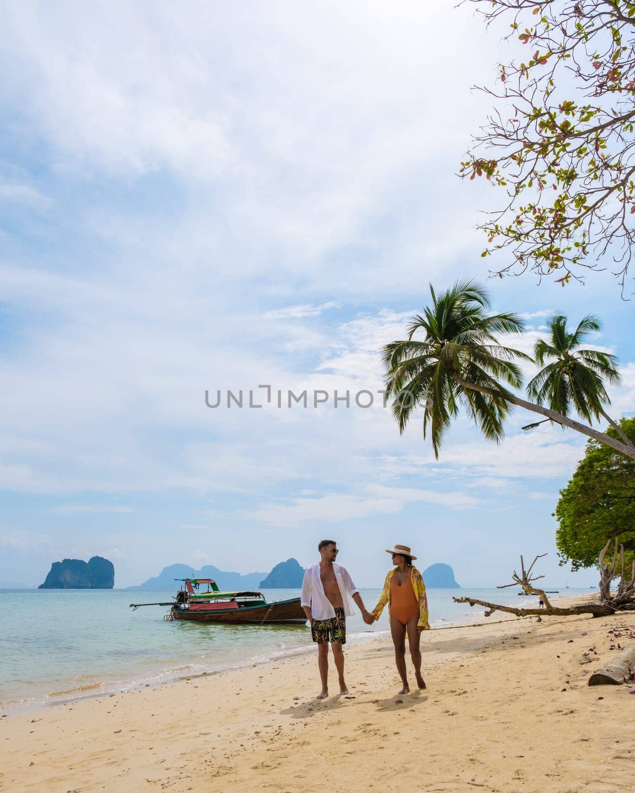 happy young couple Asian woman and European men on the beach of Koh Ngai island in Thailand by fokkebok