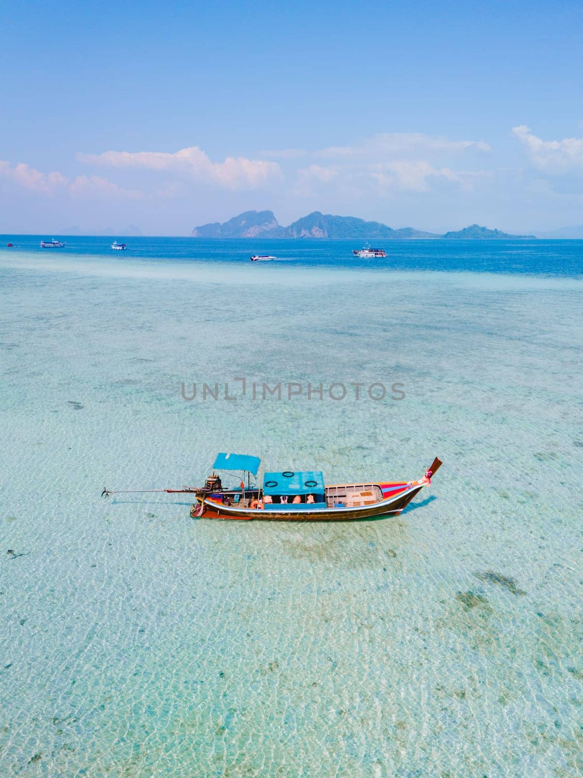 longtail boat in the blue green turqouse colored ocean with clear water at Koh Kradan a tropical island in Trang Thailand