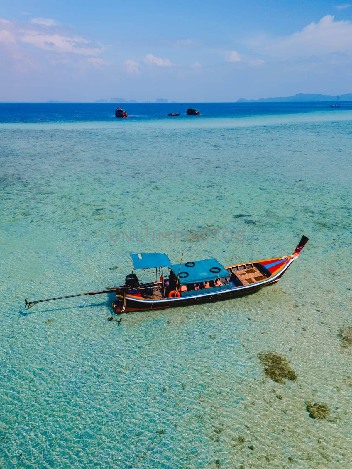 longtail boat in the turqouse colored ocean with clear water at Koh Kradan Thailand by fokkebok