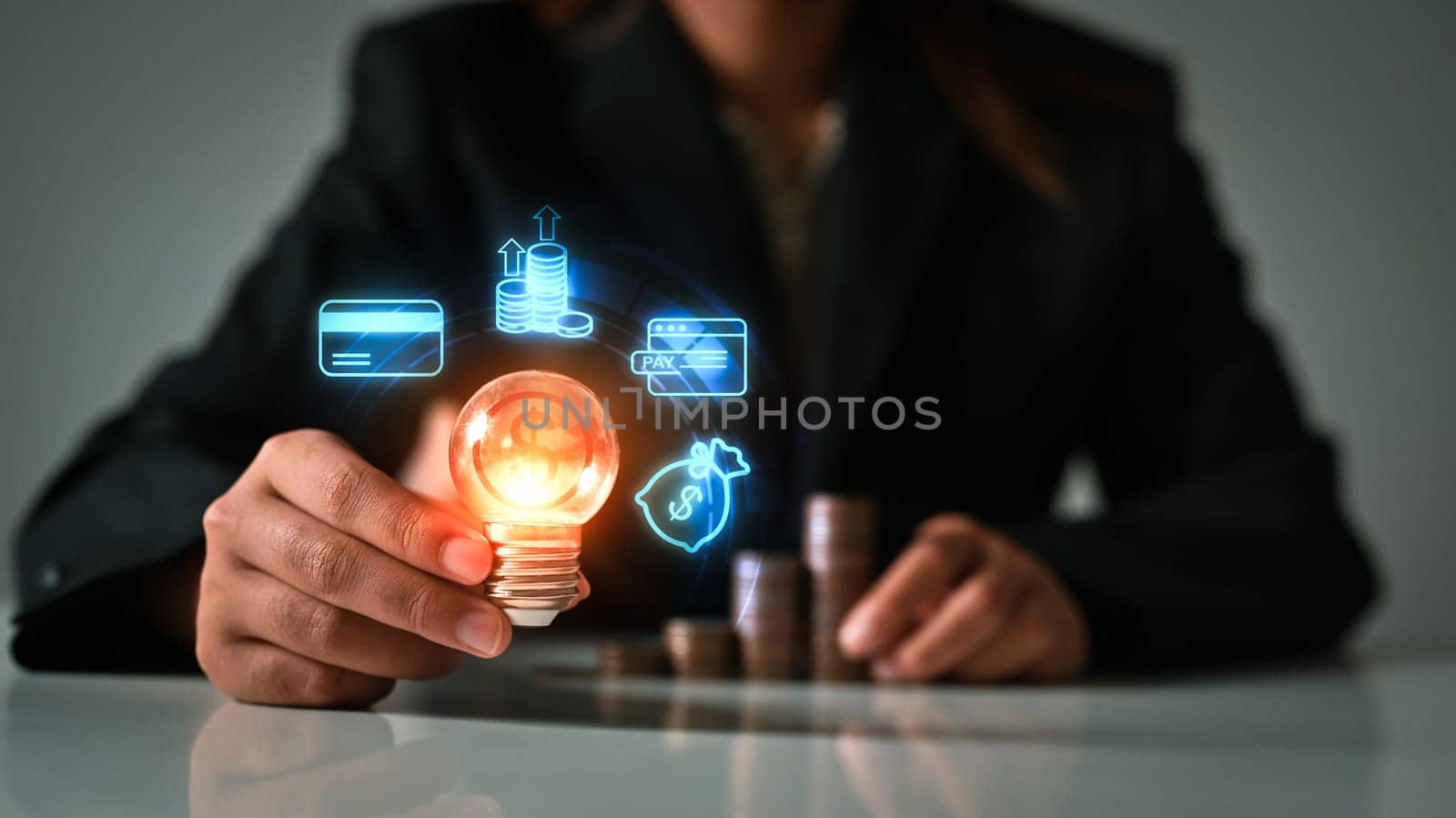 Business man hand holding glowing light bulb with virtual hologram. Investment and business Innovation ideas concept by prathanchorruangsak