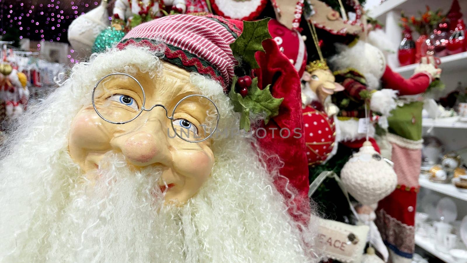 Santa Claus toy, close-up portrait with glasses. A fun Christmas event. Santa Claus doll at a Christmas festival or fair