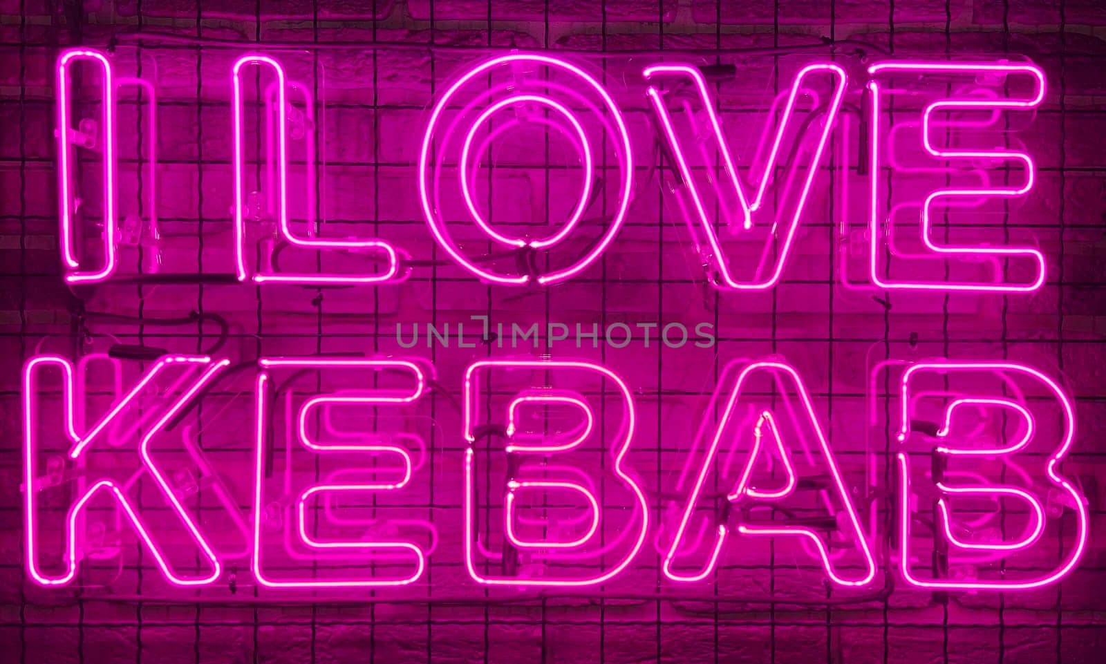Neon shining sign in pink or purple color on a brick wall with the inscription or slogan I love kebab. Brick wall, background. Bright electric neon light. Cafe-restaurant Doner Kebab