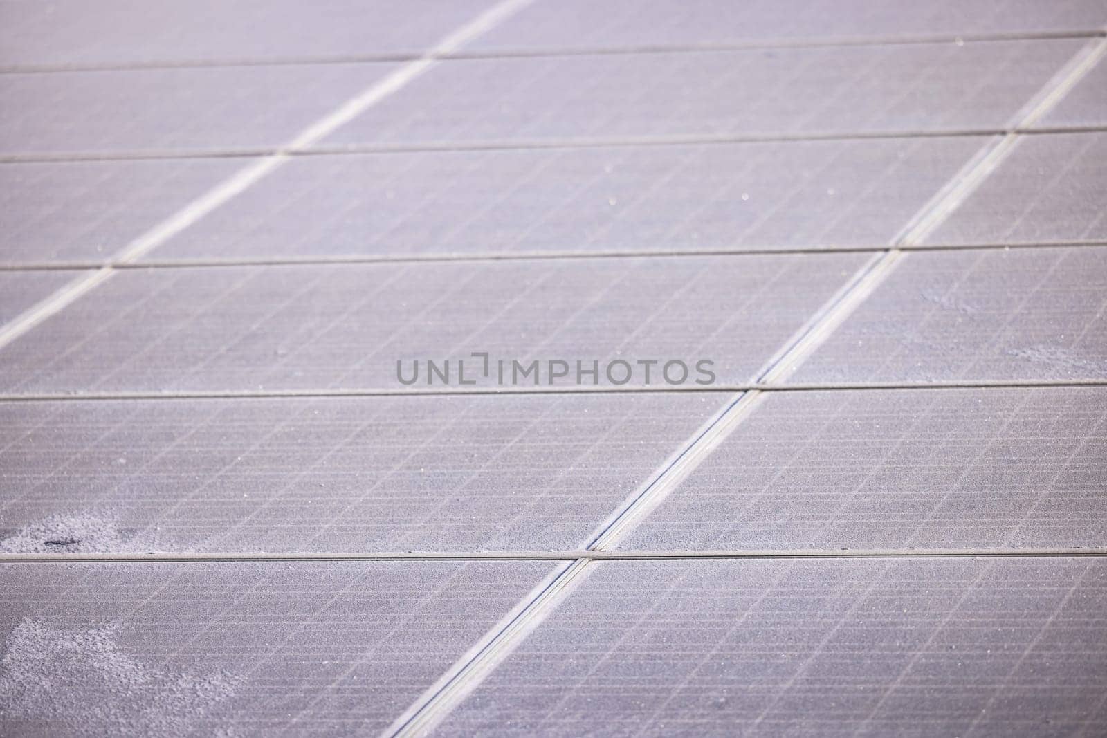 Individual iced solar panels of a PV system for the energy crisis exposed in sunlight in winter