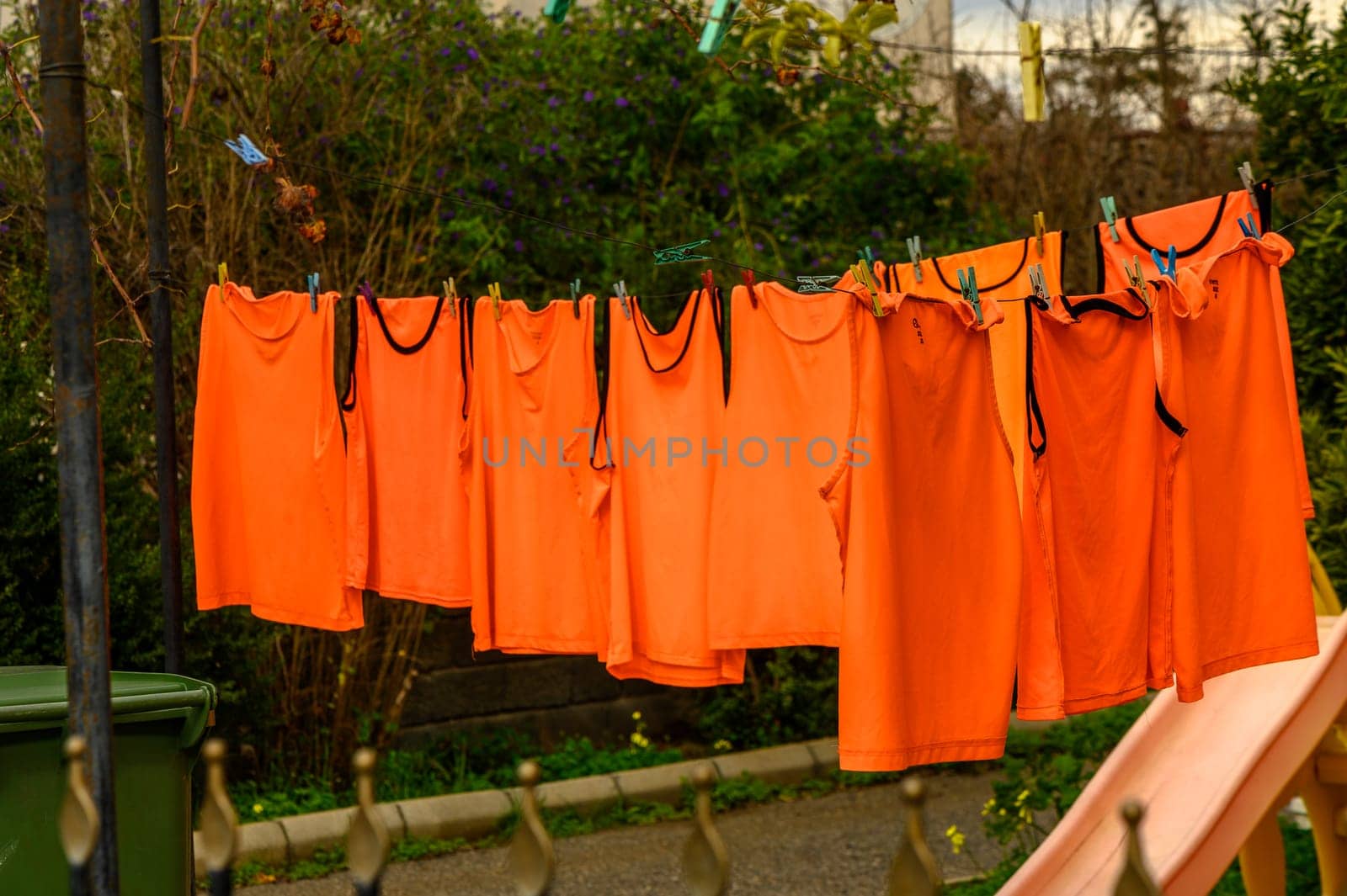 orange t-shirts drying on a line in winter in Cyprus