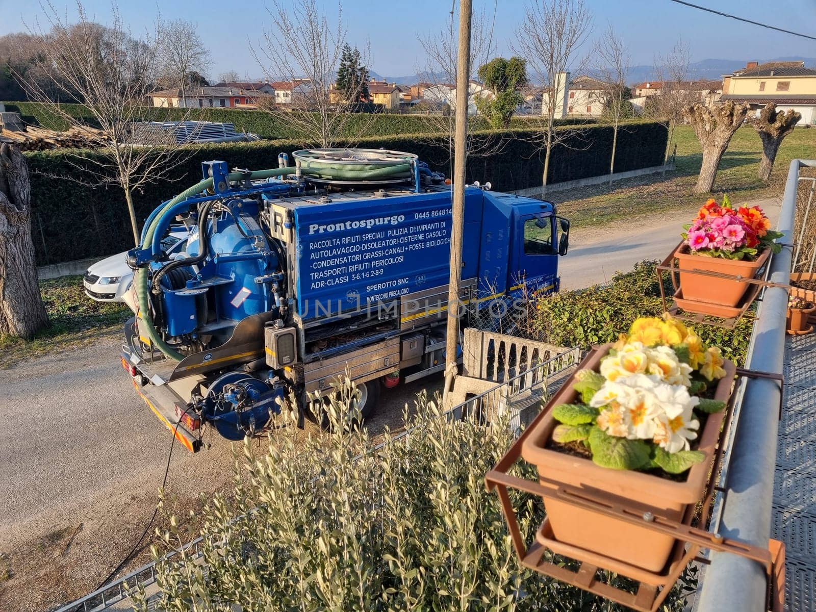 Vacuum truck parked next to flower pot on road