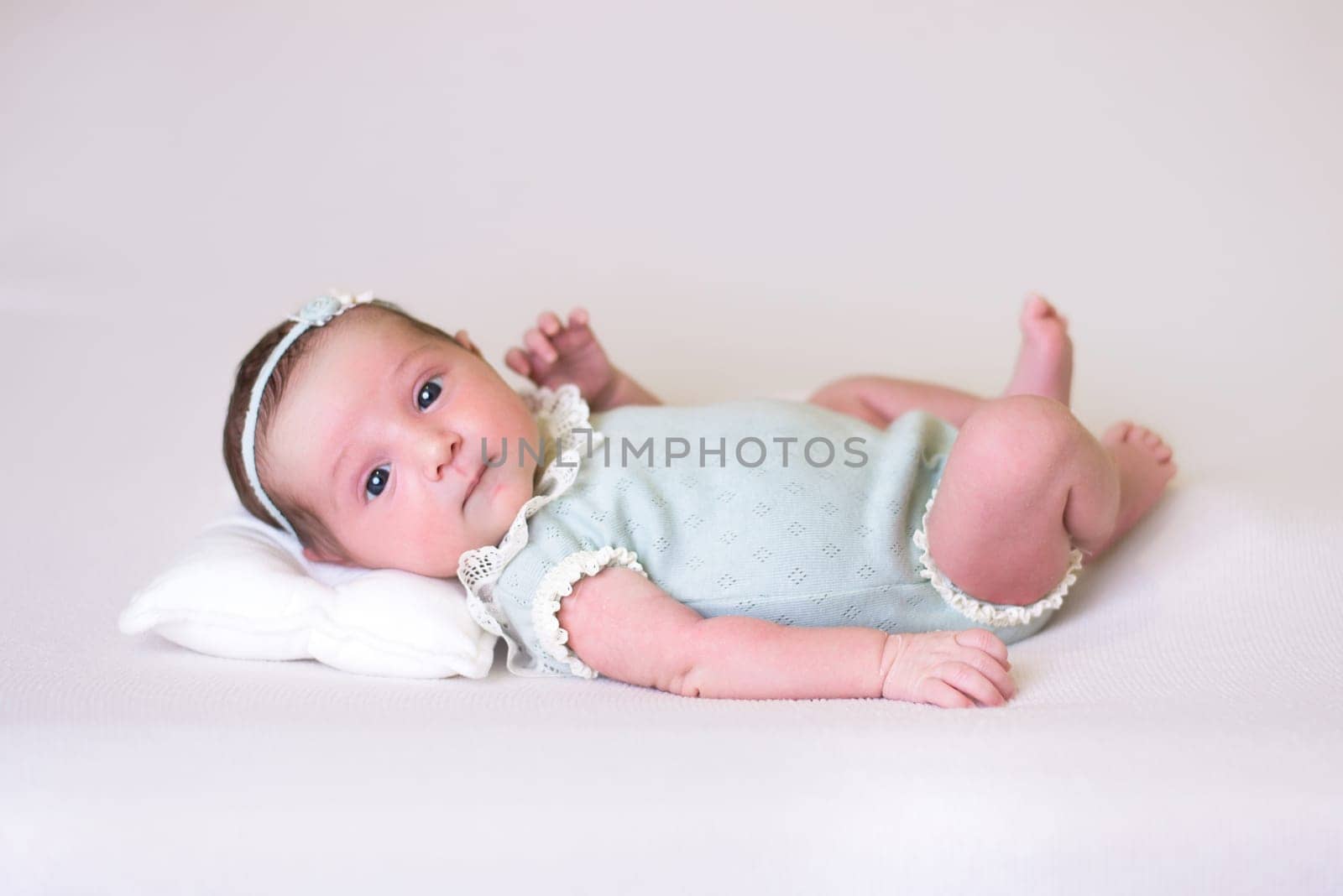 Tiny newborn girl in white cocoons on a white background. Professional studio photography by jcdiazhidalgo