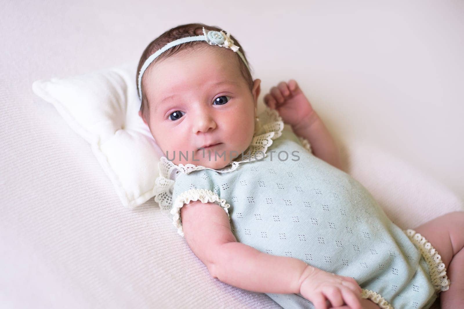 Tiny newborn girl in white cocoons on a white background. Professional studio photography.