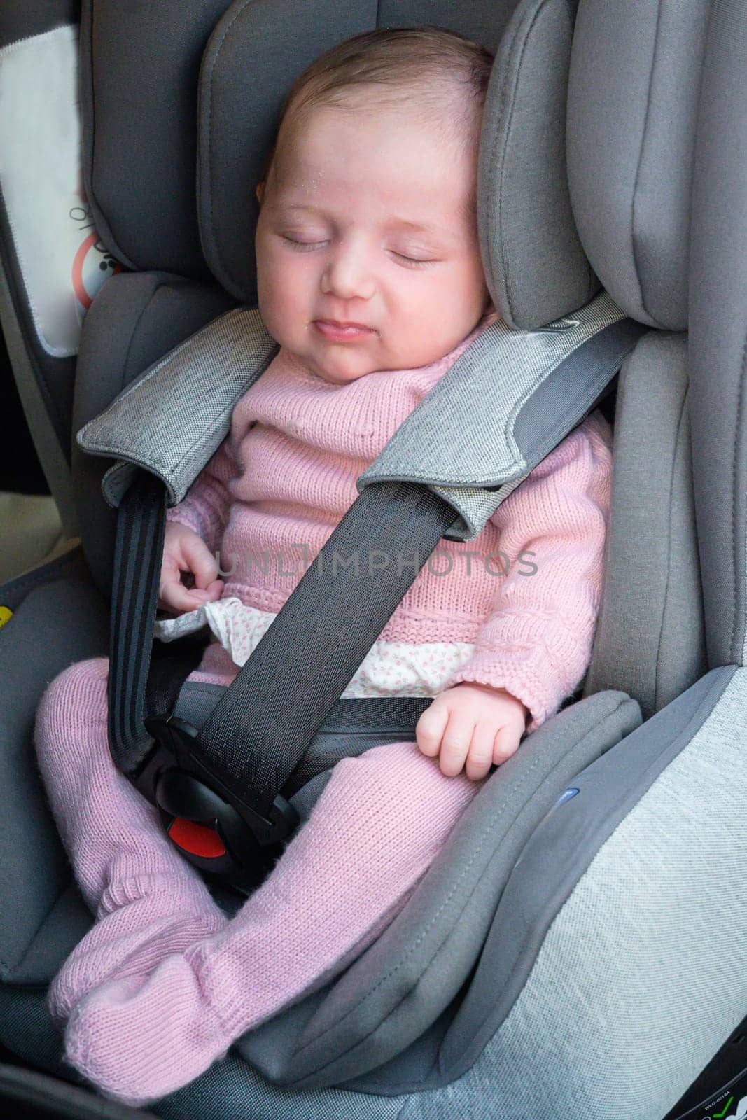 Adorable toddler girl in modern car seat. Little kid traveling by car. Child safety on the road. Trip with an infant.