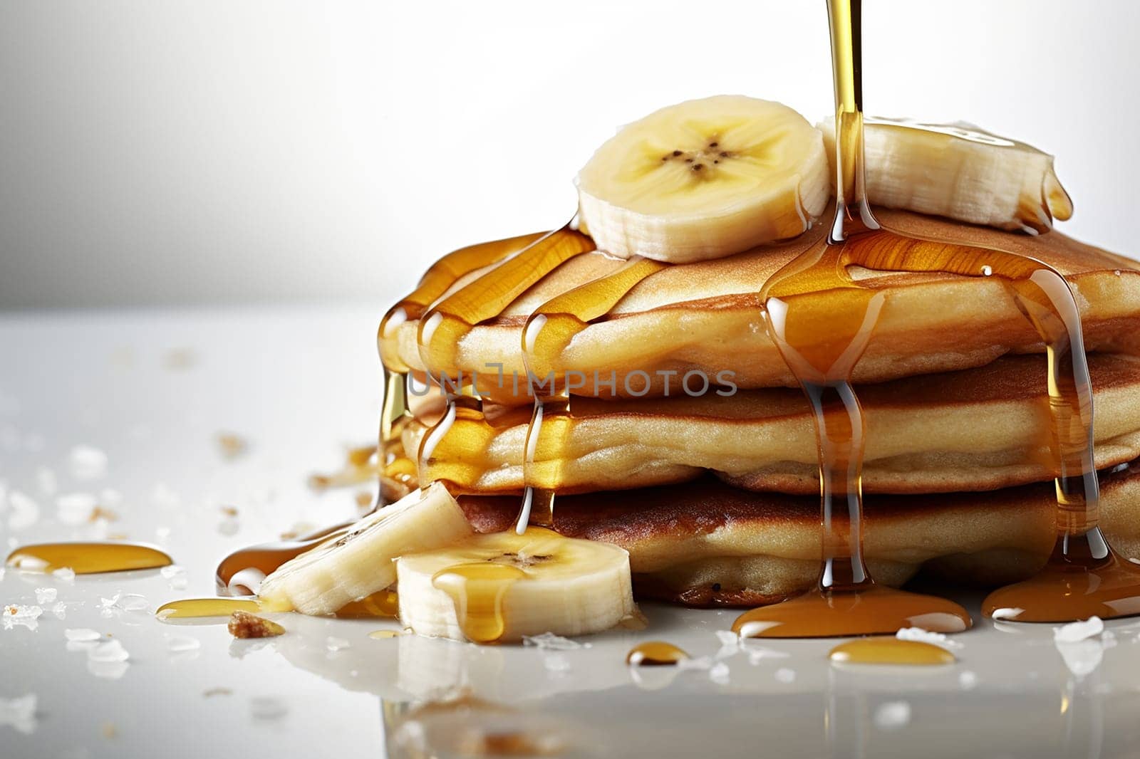 Stack of pancakes with syrup and banana slices.