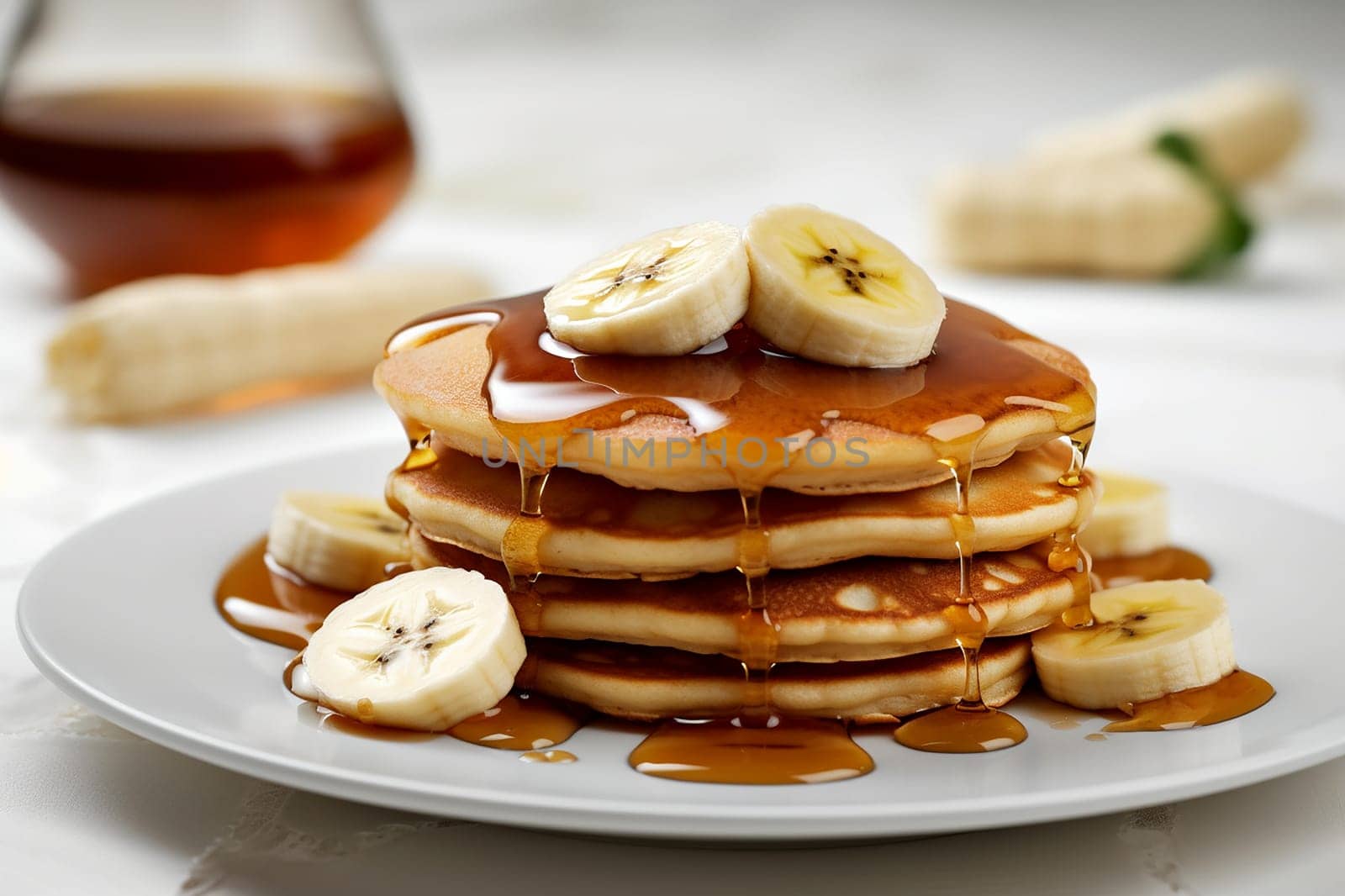 Stack of pancakes with syrup and banana slices on top.