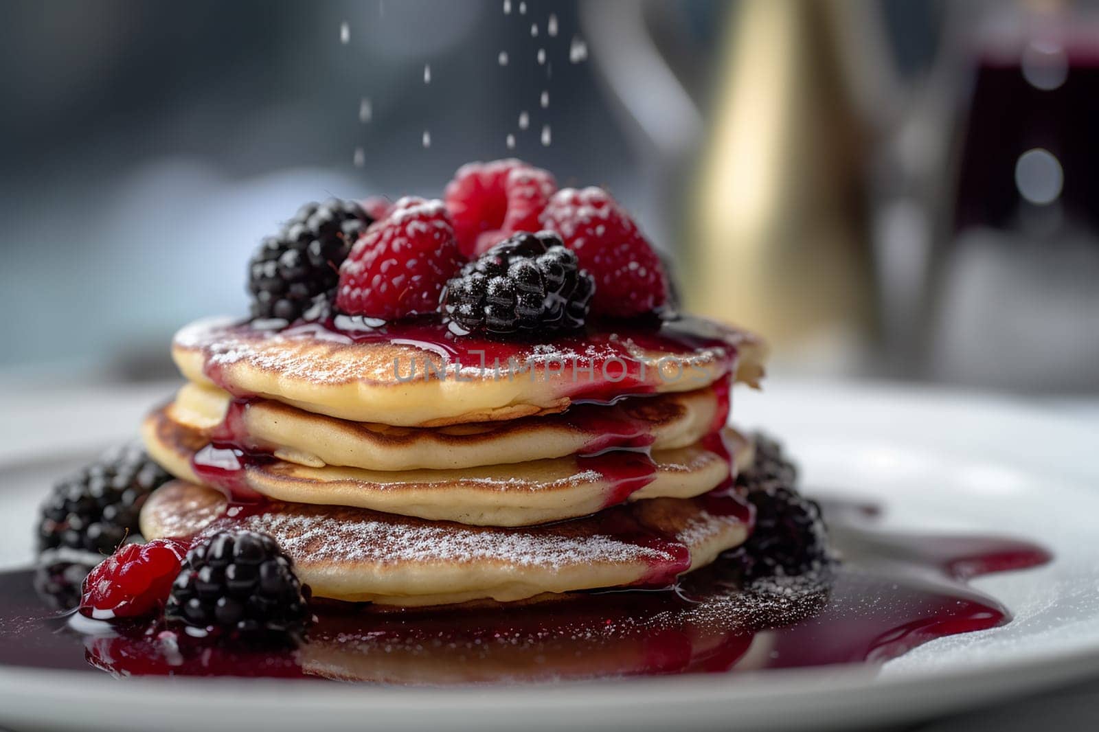 Stack of pancakes with berries and syrup.