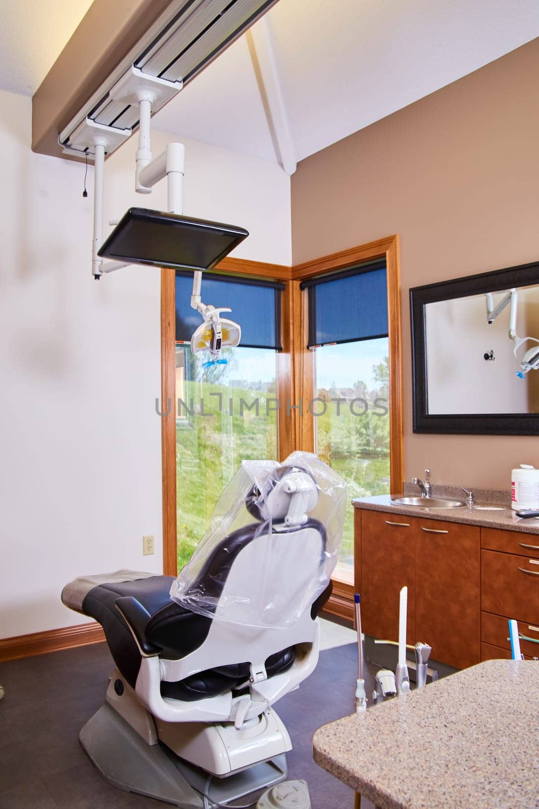 Modern, well-lit dental office in Fort Wayne, Indiana, showcasing high-tech patient chair and professional workstation, emphasizing cleanliness, comfort, and advanced care, 2017.