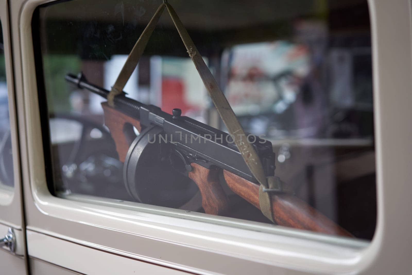 Closeup of RPD machine gun hanging inside car window. Powerful firearm against the backdrop of the car interior.