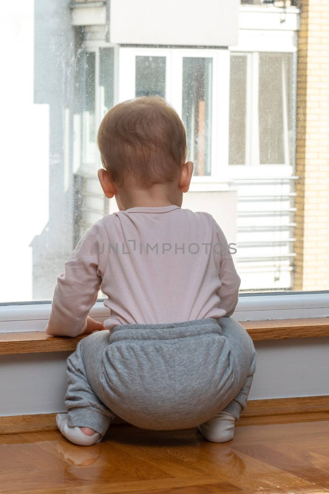 Baby looks out window, wants to play outside. Concept of wanting more fun by Mariakray
