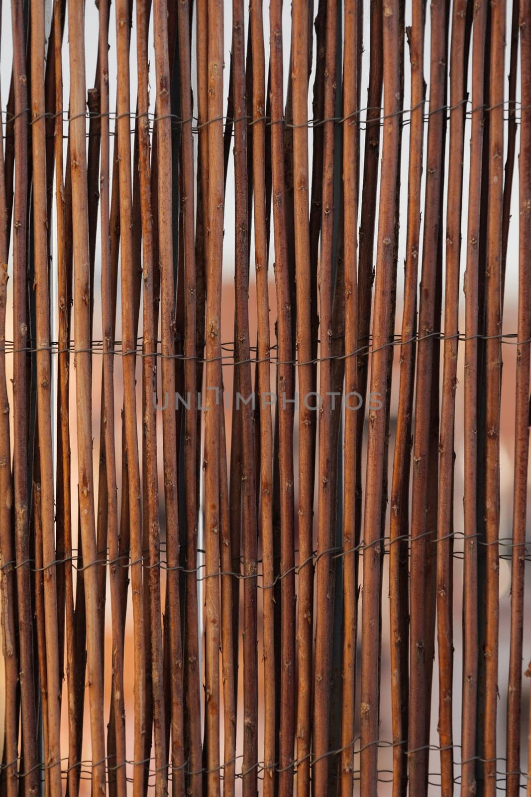 Close-up of a rustic brown twig fence creating a natural texture pattern