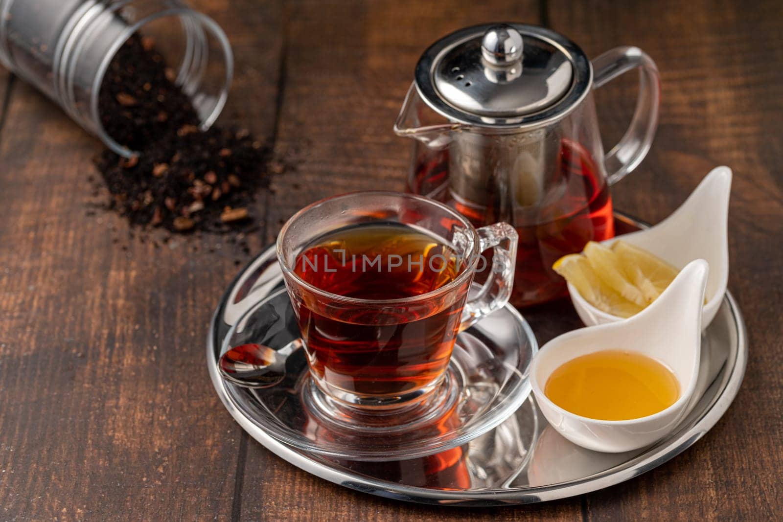 Top view of traditional black turkish tea with lemon and honey on wooden background by Sonat