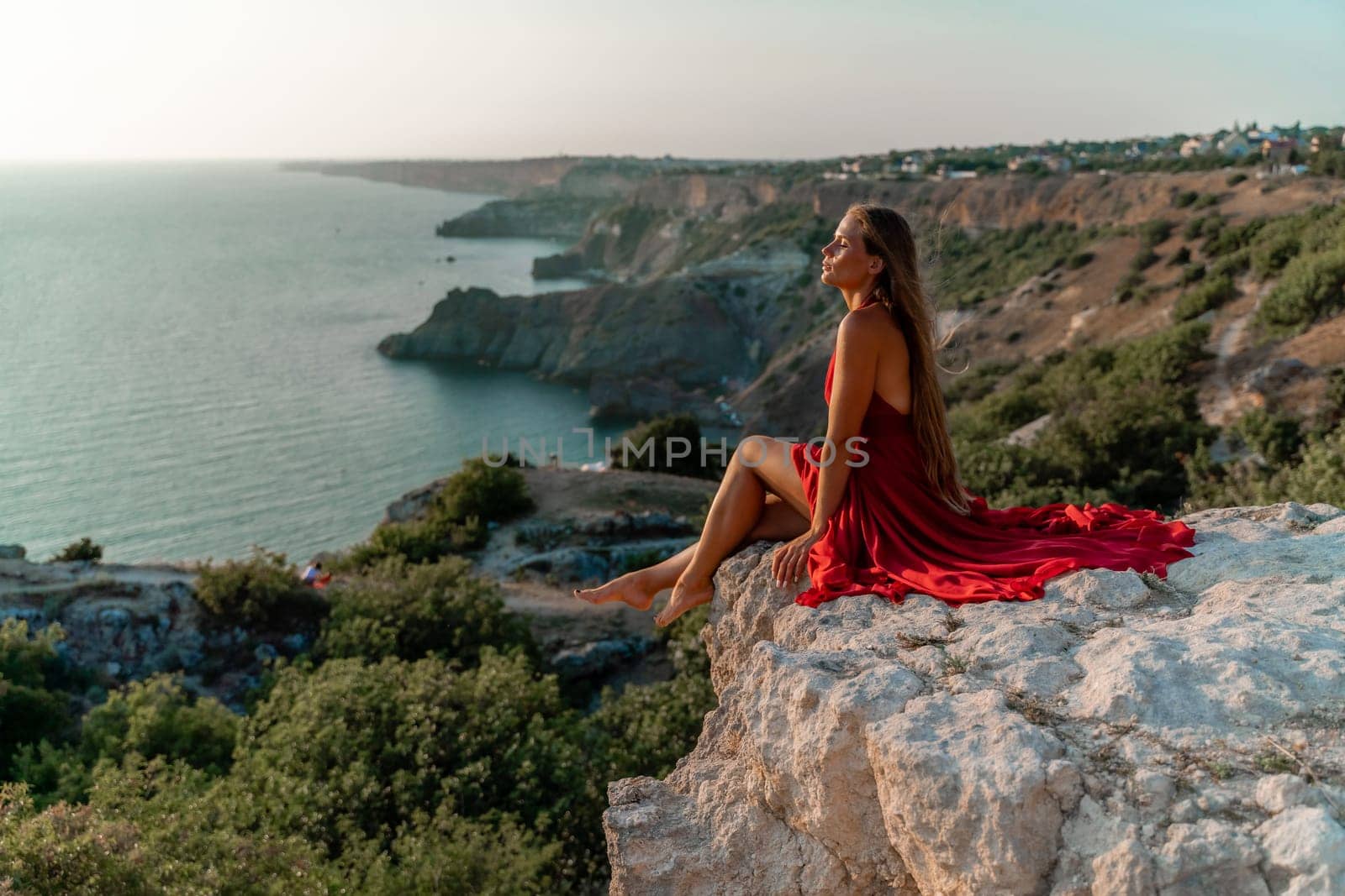 Woman sunset sea red dress, portrait happy beautiful sensual woman in a red long dress posing above the sea on sunset. by Matiunina