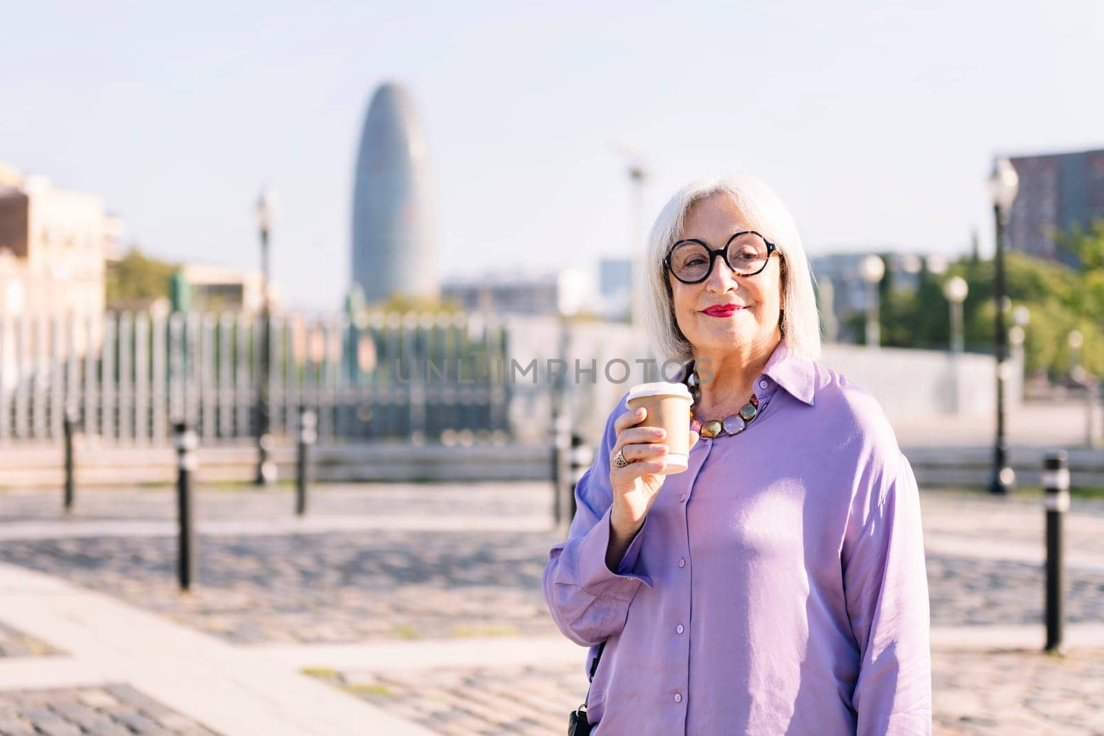 portrait of a smiling senior woman with a takeaway coffee, concept of elderly people leisure and active lifestyle