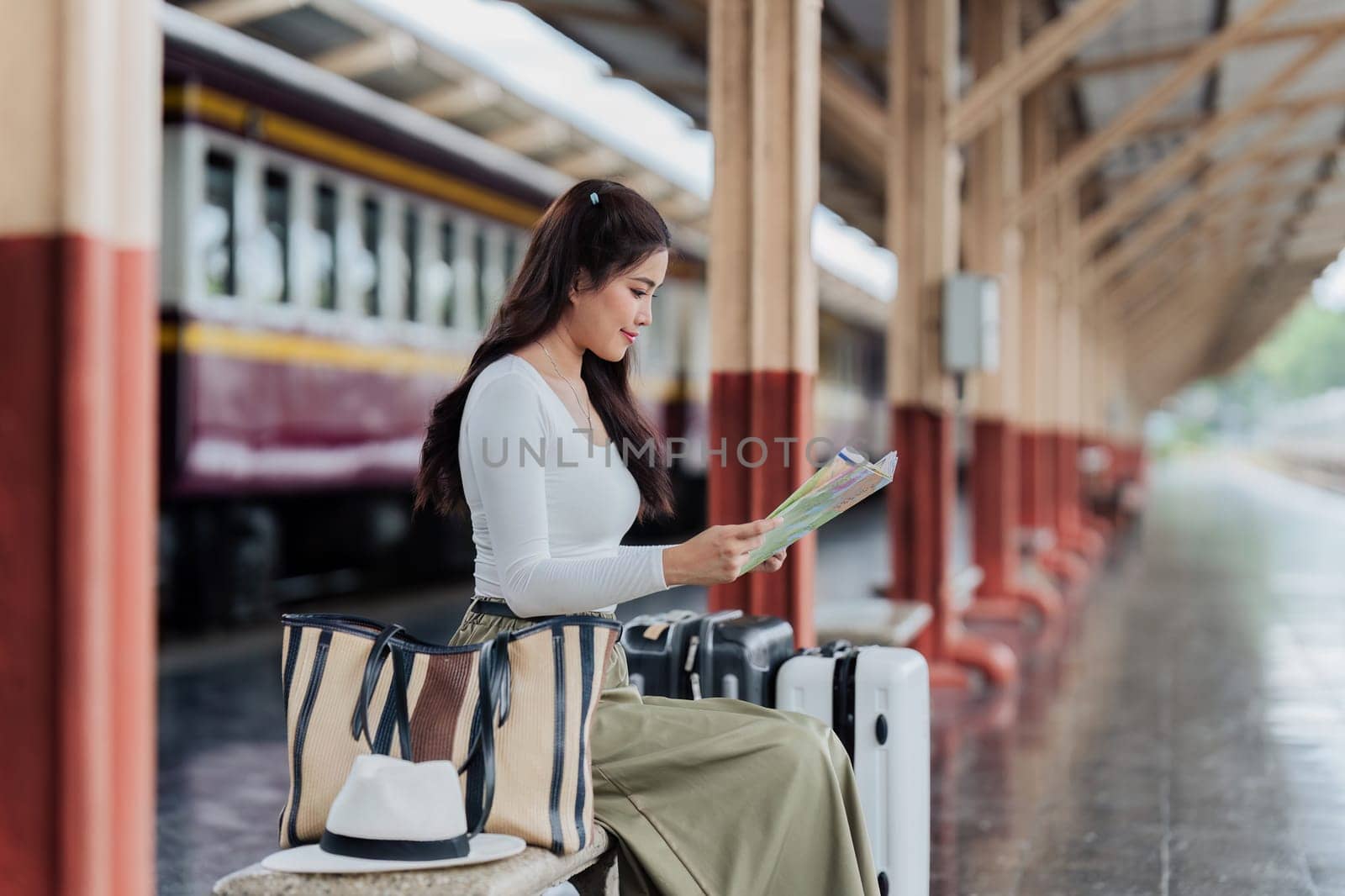 Woman traveler tourist walking with luggage at train station. Active and travel lifestyle concept.