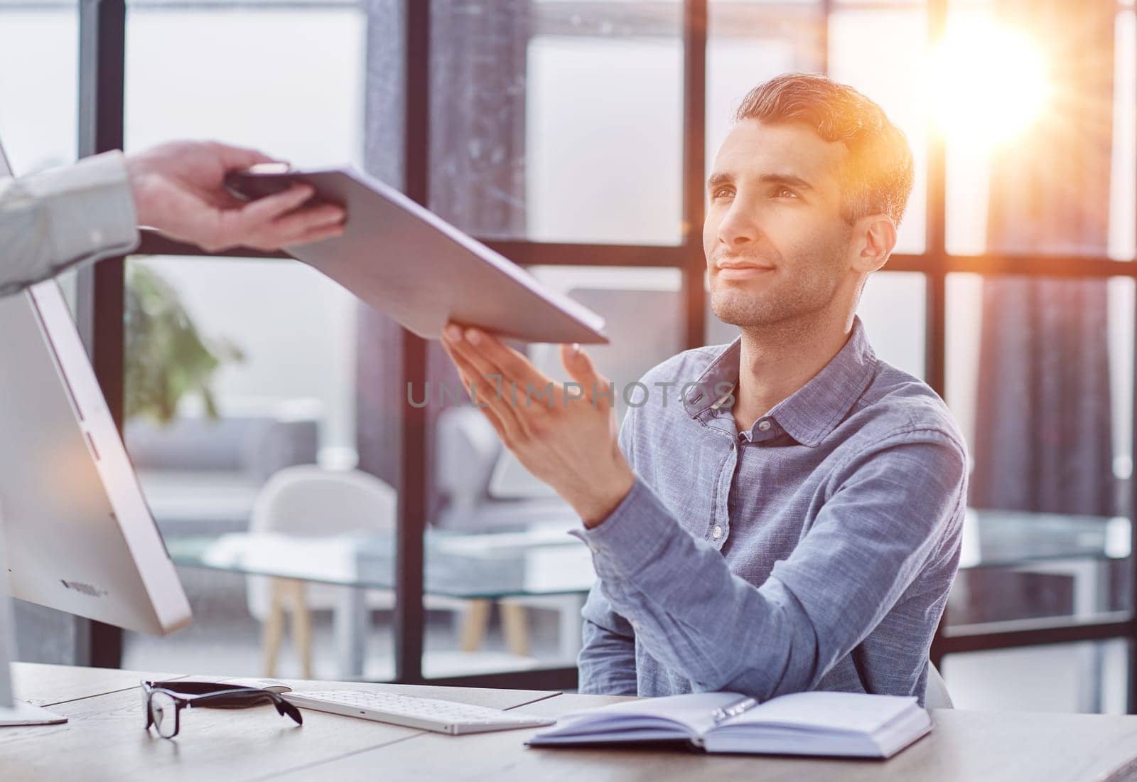 Confident businessman passing papers at meeting. Board meeting concept