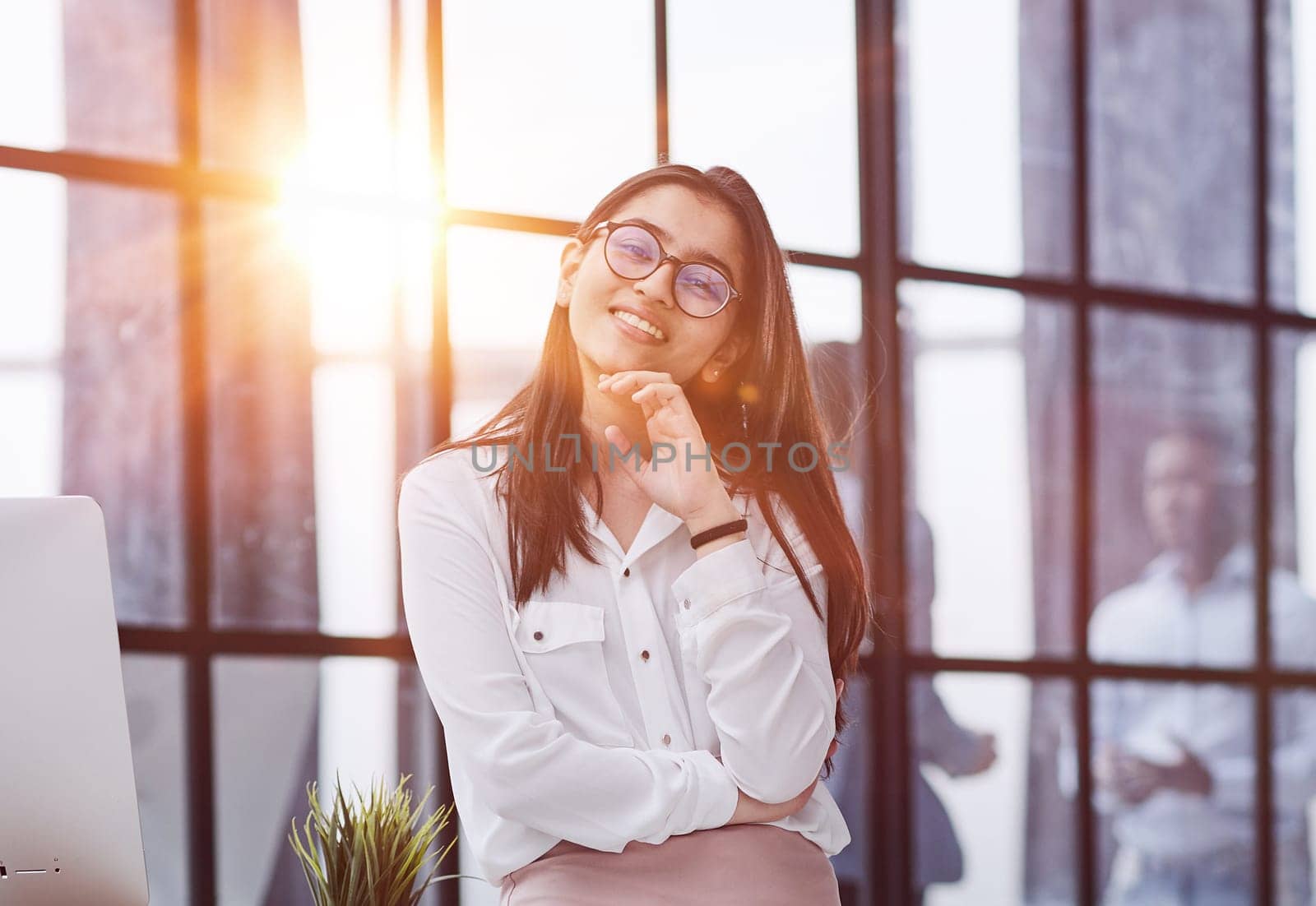 business woman standing in full length and looking at the camera with her hands crossed in the office