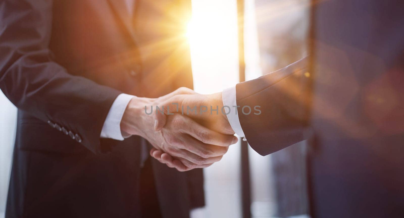 businessmen meeting and handshake in front of business center buildings by Prosto