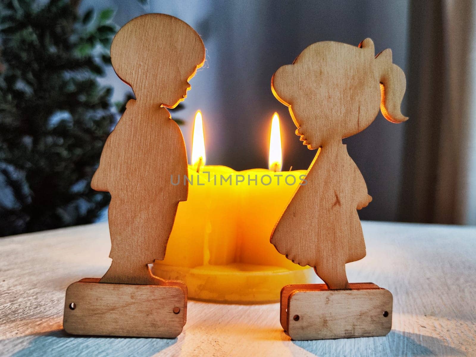 Wooden toys of boy and girl with yellow candles. Couple in love on Valentine's Day. Celebration of love, friendship. Card, background by keleny