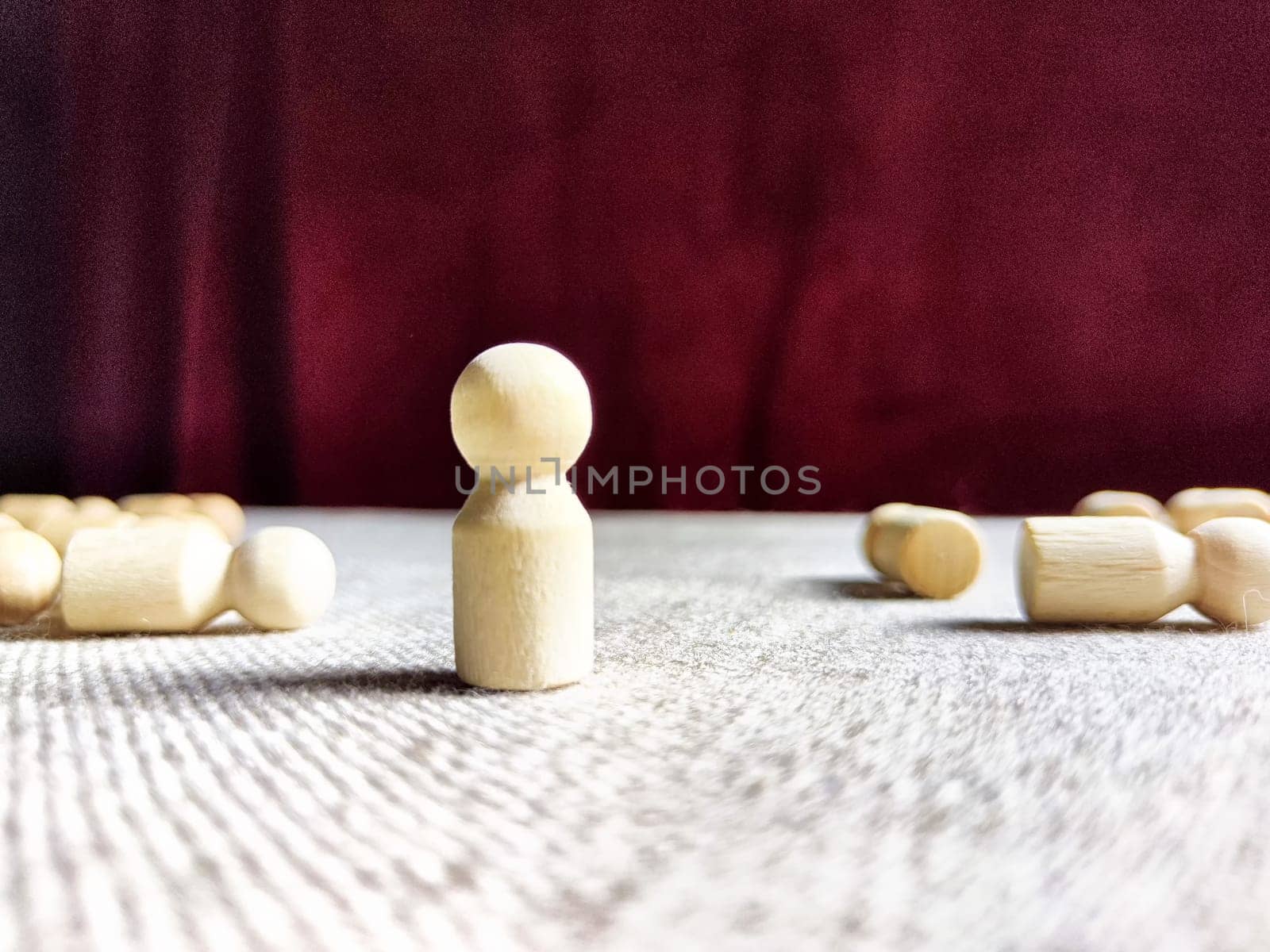 A lot of lying wooden toys and one standing one. There is an opportunity to win even when others give up. The strongest ones win. The loneliness of leader in business