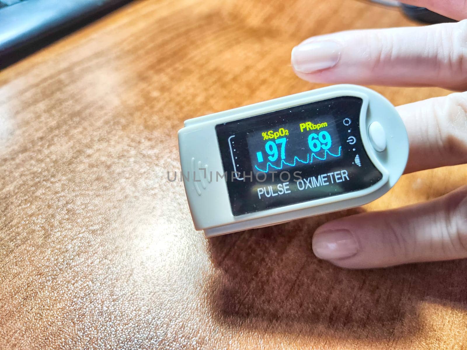 Close up of hand with a pulse oximeter on the finger.