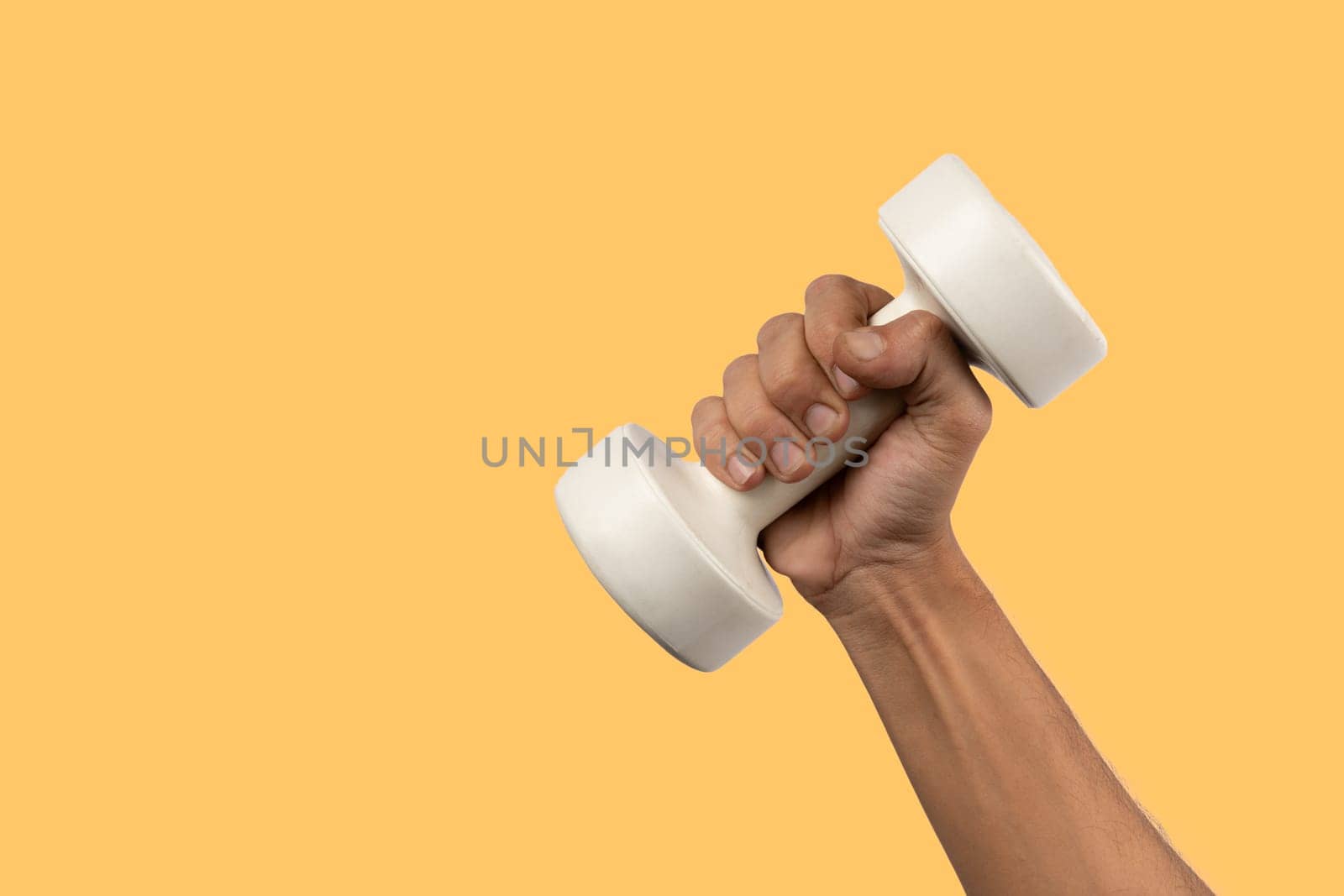 Black male hand holding a white dumbell isolated, yellow background. High quality photo
