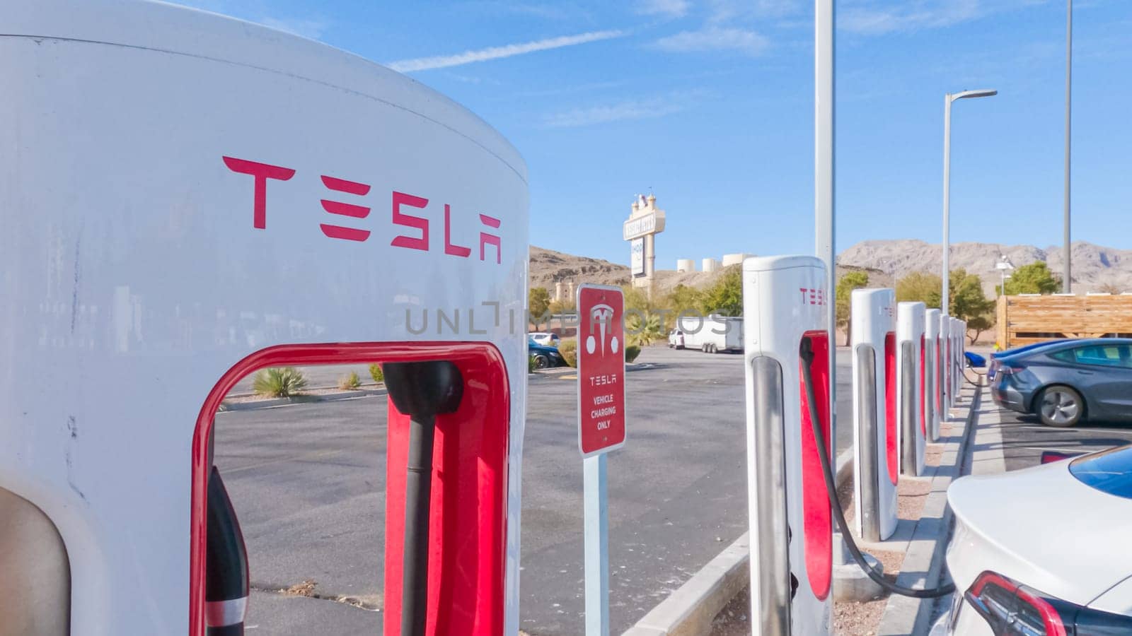 Daytime Tesla Charging: Supercharging Station Power-Up by arinahabich