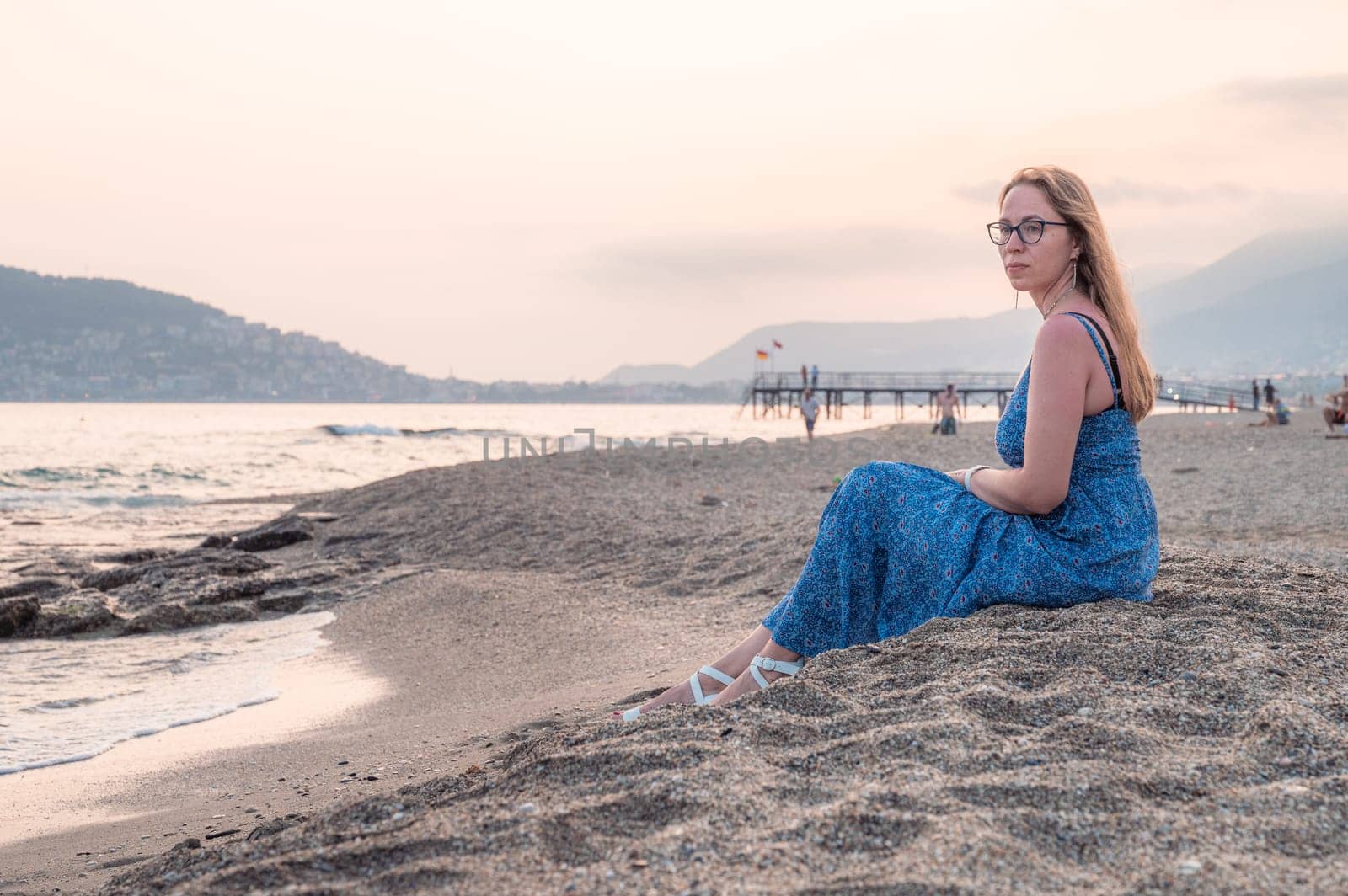 Woman sits on the beach and looks at the sea in Alanya city by rusak