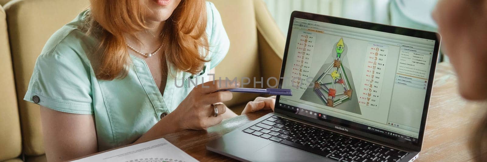 Tver, Russia-august 7, 2022. A woman with a laptop is studying human design. The concept of studying esoteric sciences. Studying rave postcards from human design.