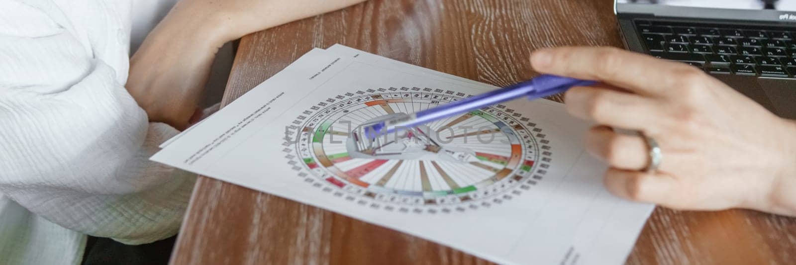 Tver, Russia - August 2, 2021. A woman in a cafe at a table is studying the design of a person. The concept of studying esoteric sciences. A bodigraph or a map of a person on an A4 sheet.