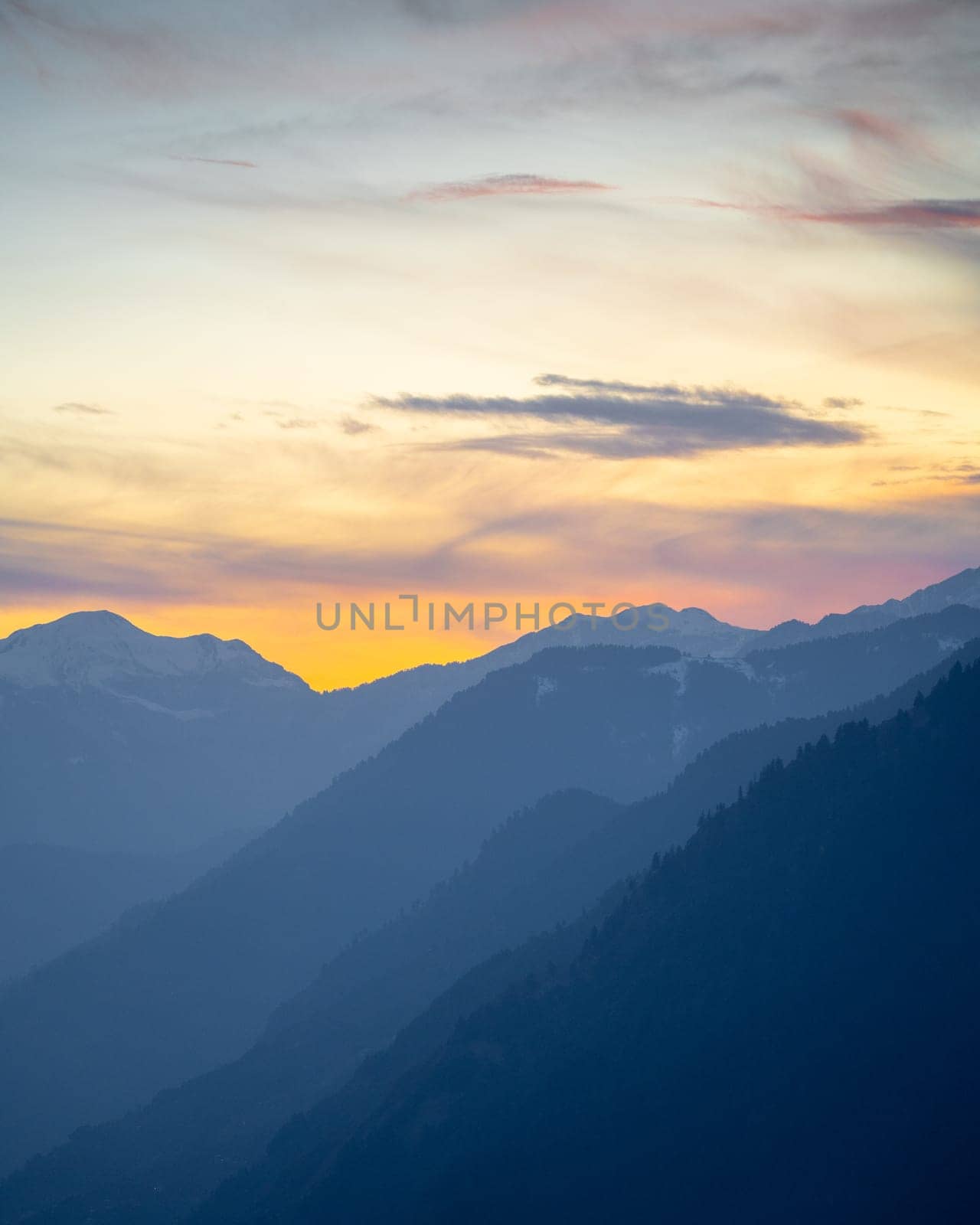 Sunrise sunset dusk dawn colors over the himalaya mountains with fog haze in distance with rich orange and red colors in manali kullu shimla by Shalinimathur