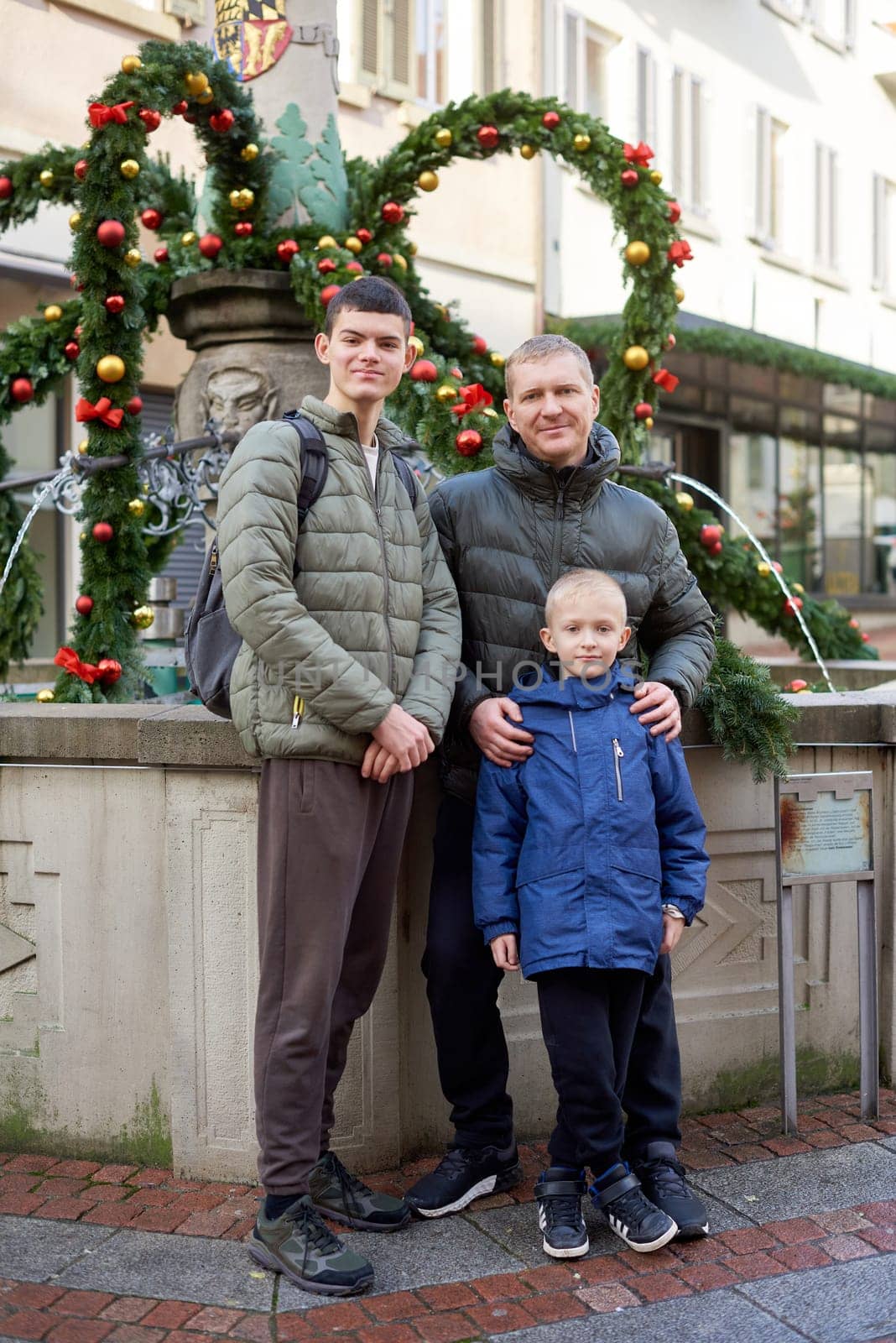 Joyful Family Portrait: Father and Two Sons by Festive Vintage Fountain. by Andrii_Ko