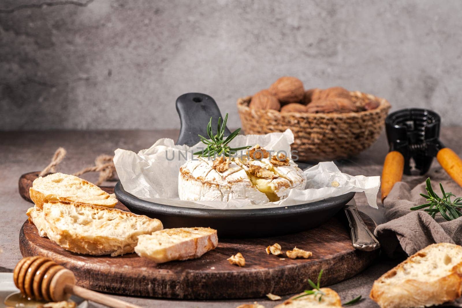 Brie type of cheese. Camembert cheese. Fresh sliced Brie cheese on a wooden tray with nuts, honey and leaves. Italian, French cheese.