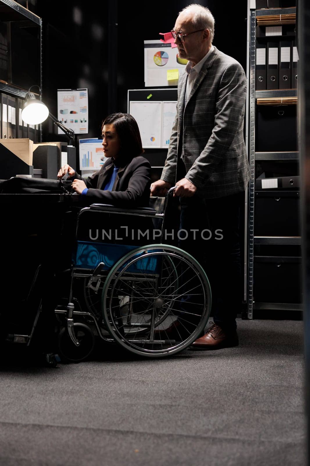Paralyzed executive in wheelchair at desk by DCStudio