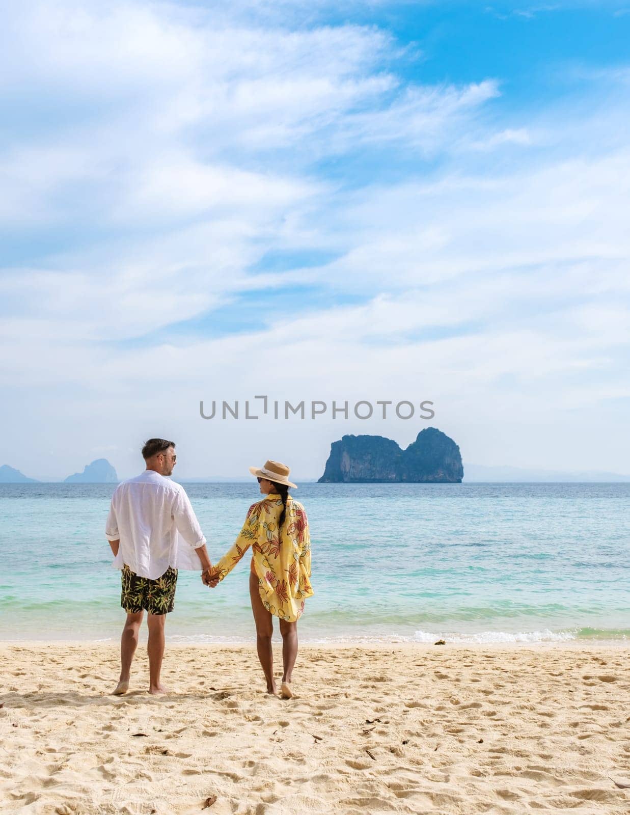 happy young couple Asian woman and European men on the beach of Koh Ngai island in Thailand by fokkebok