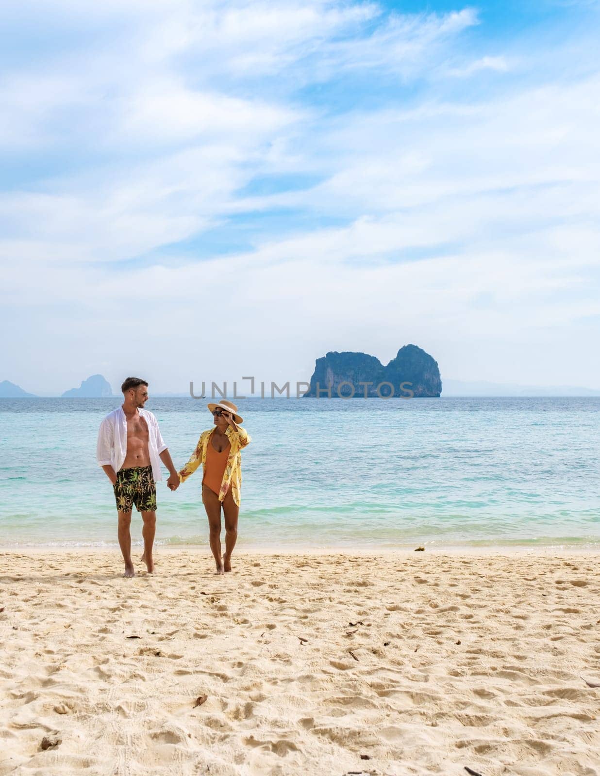 happy young couple Asian woman and European men on the beach of Koh Ngai island in Thailand by fokkebok