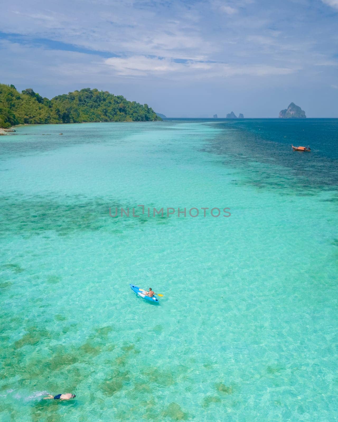 Young men in a kayak at the bleu turqouse colored ocean of Koh Kradan Thailand, a tropical island with a coral reef in the ocean, Koh Kradan Trang Thailand