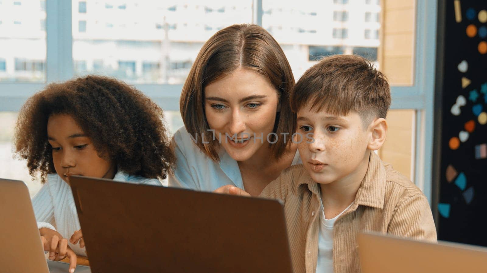 African girl play laptop with diverse friend learning prompt at STEM technology class. Multicultural student study about engineering code and programing system with blurring background. Erudition.